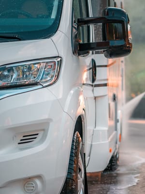 a man washing the exterior of his motorhome as part of his RV maintenance checklist